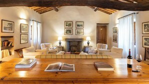 A cozy living room with a fireplace, wooden beams, and comfortable seating. - Castello di Fonterutoli Wine Resort (Castellina in Chianti)
