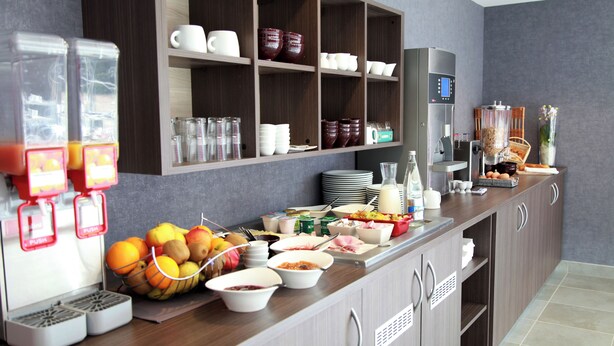 A breakfast bar with various food items, a coffee machine, and a fruit bowl. - Brit Hotel Vannes-Theix (Theix-Noyalo)