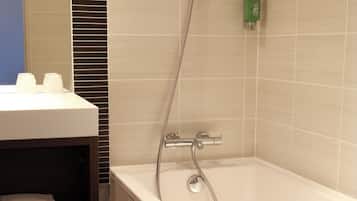Une salle de bain moderne équipée d’une baignoire, d’une douche et d’un porte-serviettes.