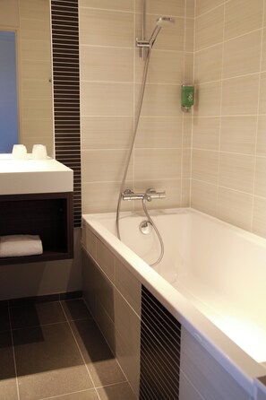 Een moderne badkamer met een badkuip, een douchekop en een handdoekhouder.