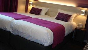 A hotel room with two beds, each with white linens and purple accents, and bedside lamps. - Brit Hotel Vannes-Theix (Theix-Noyalo)