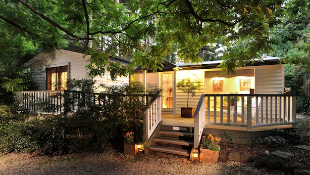A house with a wooden deck, a staircase, and a front door. - Clarendon Cottages (Sassafras)