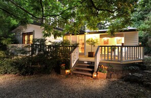 A house with a wooden deck, a staircase, and a front door. - Clarendon Cottages (Sassafras)
