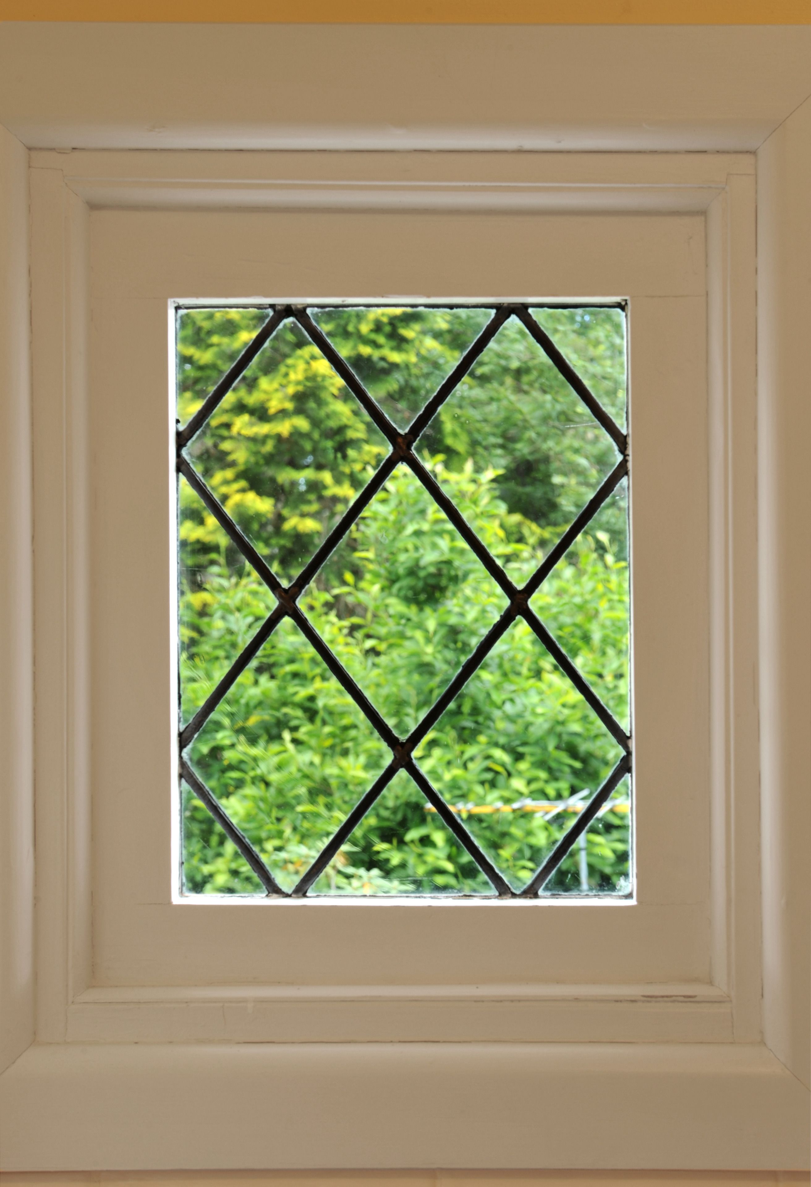 Una ventana con una celosía de diseño de rombos.