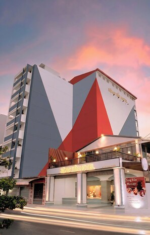 A hotel with a modern design, featuring a prominent geometric facade and a visible entrance with a sign. - Song Tien Hotel (My Tho)