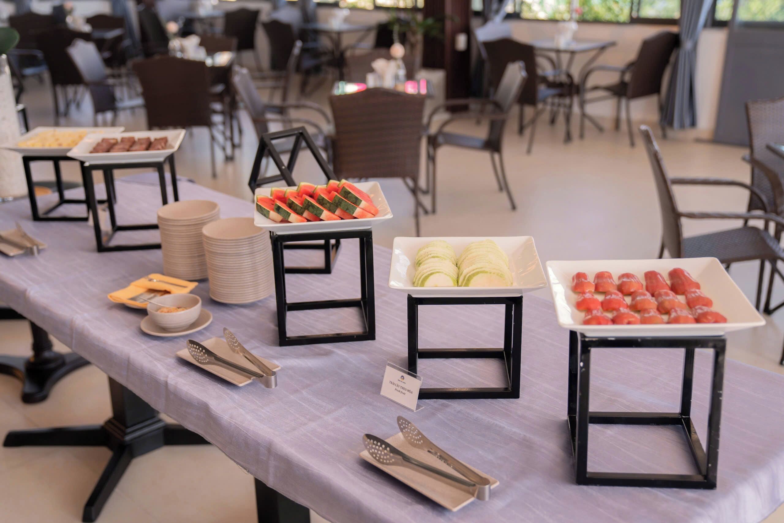 Una mesa de buffet con diversos alimentos y utensilios de servicio.