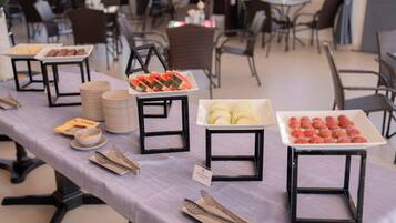 Una mesa de buffet con diversos alimentos y utensilios de servicio.