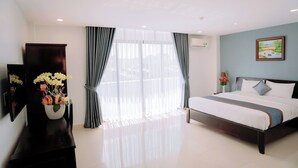 A hotel room with a bed, a TV, a dresser, and a window with curtains. - Song Tien Hotel (My Tho)