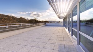 A rooftop terrace with a modern design, featuring a glass railing and a view of the cityscape. - Spark by Hilton Lyon Ouest (Lyon)