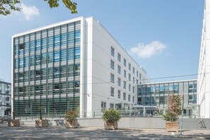 A modern building with large glass windows, a flat facade, and a clean, white exterior. - Spark by Hilton Lyon Ouest (Lyon)