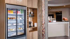 A modern retail area with a refrigerated display and a coffee station. - Spark by Hilton Lyon Ouest (Lyon)