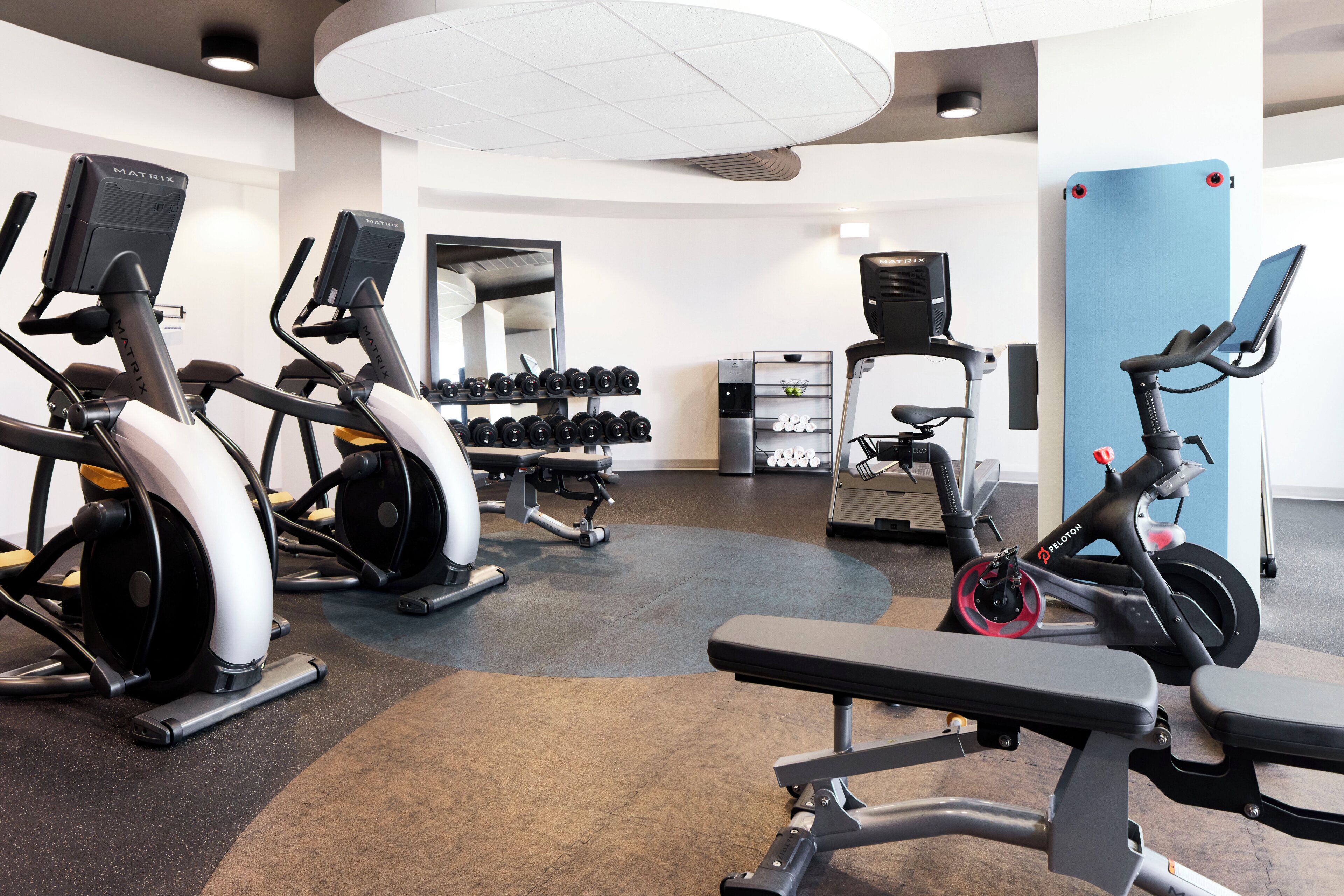 A gym with various exercise equipment including treadmills, elliptical machines, and a stationary bike.