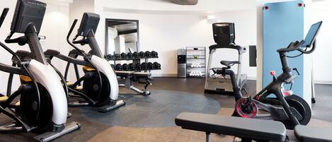 A gym with various exercise equipment including treadmills, elliptical machines, and a stationary bike.