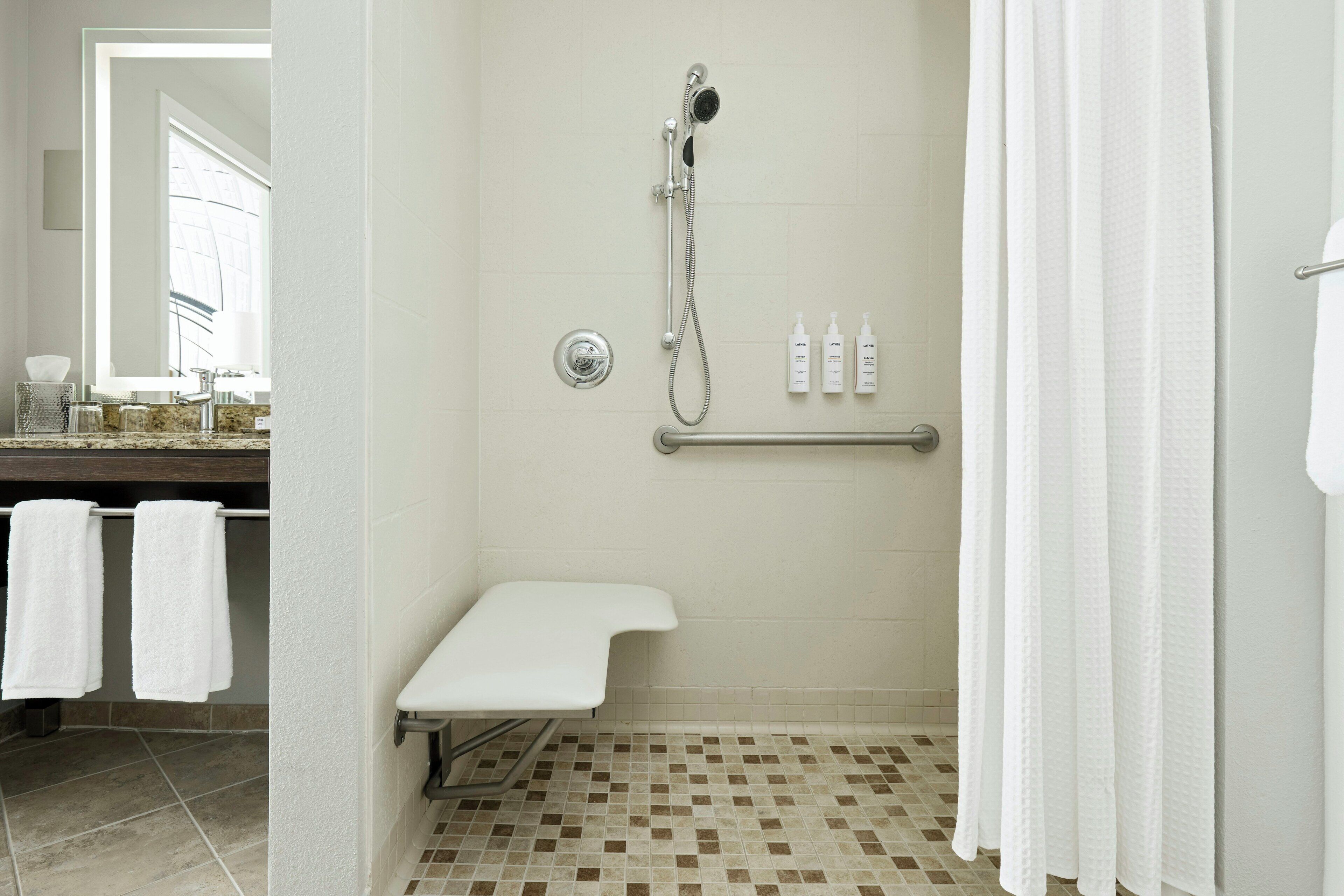 A bathroom with a shower, a toilet, and a sink.