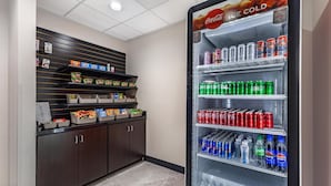 Un distributeur automatique rempli de diverses boissons et collations, notamment du Coca-Cola, du Sprite et des Doritos.