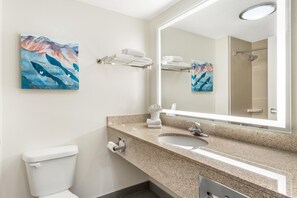 A bathroom with a sink, mirror, towel rack, and toilet.