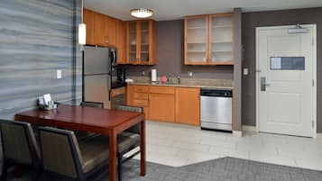 A modern kitchen with wooden cabinets, a stainless steel refrigerator, and a dishwasher.