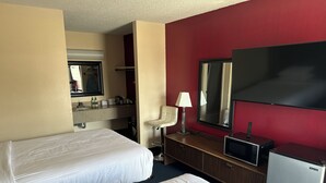 A hotel room with two beds, a desk with a lamp, a TV, and a minibar. - Classic Inn Early (Early)