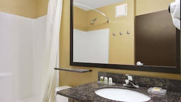 Un baño con un lavamanos blanco, un espejo grande, una cortina de ducha y una toalla colgada en la pared.