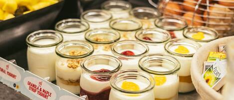 Una variedad de parfait de yogur en frascos de vidrio con distintos ingredientes.