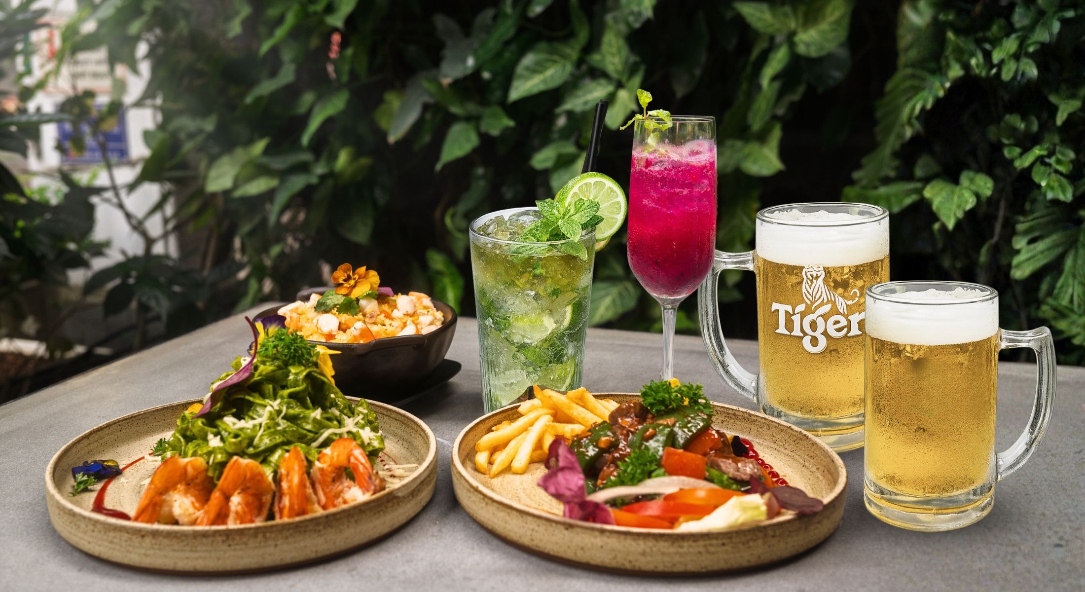 A table with food and drinks, including seafood, salads, and beer.
