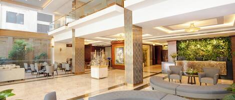 A spacious lobby with a reception desk, seating area, and a decorative wall.
