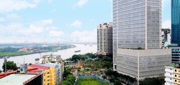 A high-rise building with a modern glass facade, surrounded by other buildings and a river in the background.