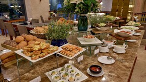 Un buffet proposant une variété de plats et un vase rempli de fleurs.