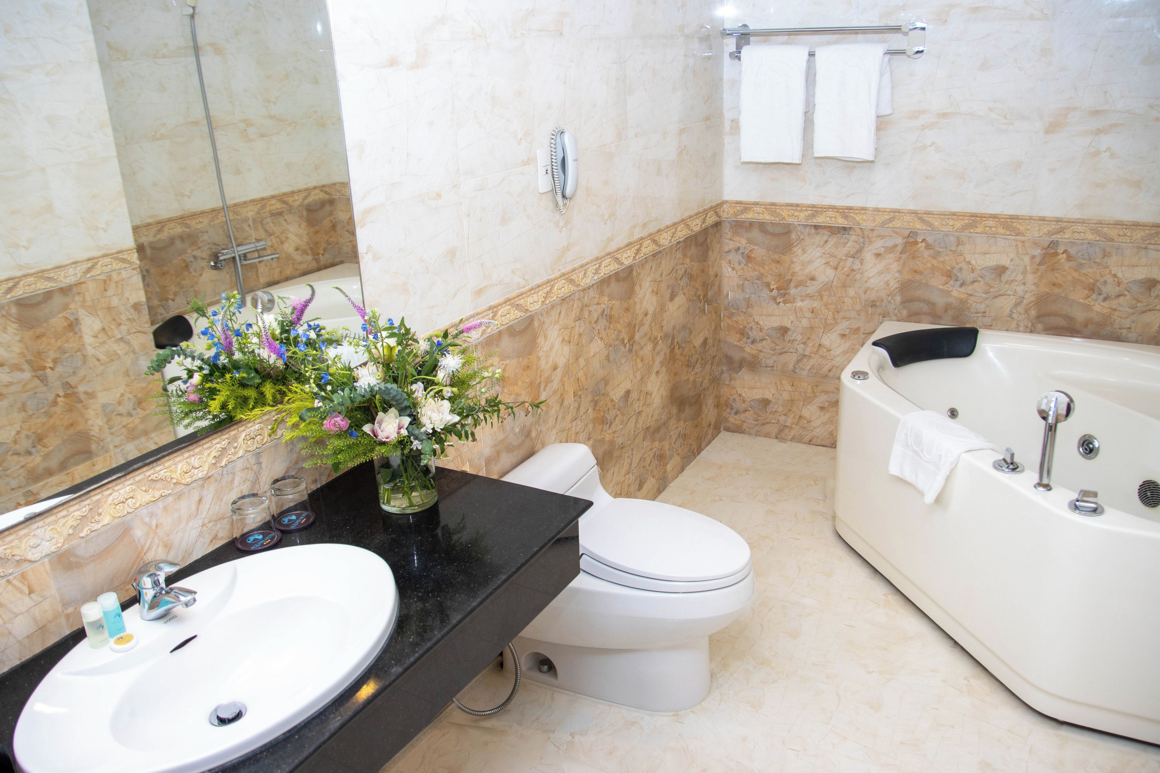 Un bany amb una banyera blanca, un vàter, un lavabo i un mirall.