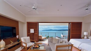 A modern hotel room with a balcony, a TV, a sofa, a coffee table with fruit, and a bed. - The Terrace Club Wellness Thalasso At Busena (Nago)