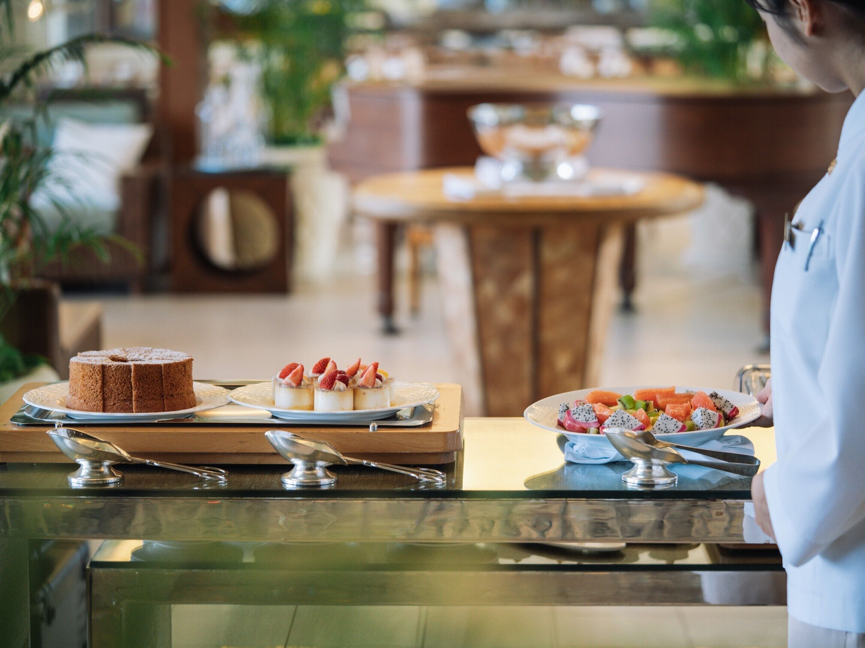 Una mesa de buffet con diversos postres y frutas.