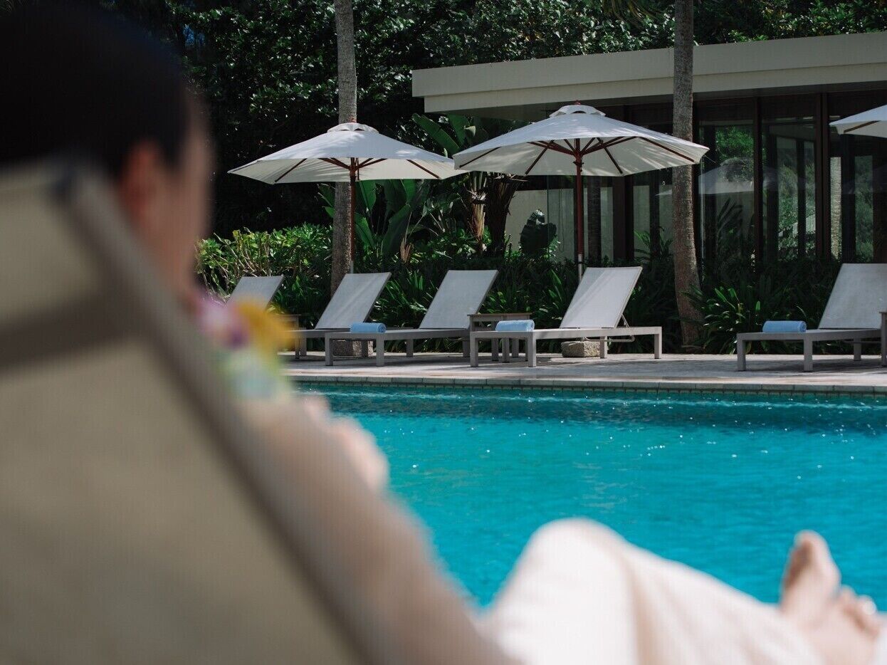 Un espace piscine équipé de chaises longues et de parasols.
