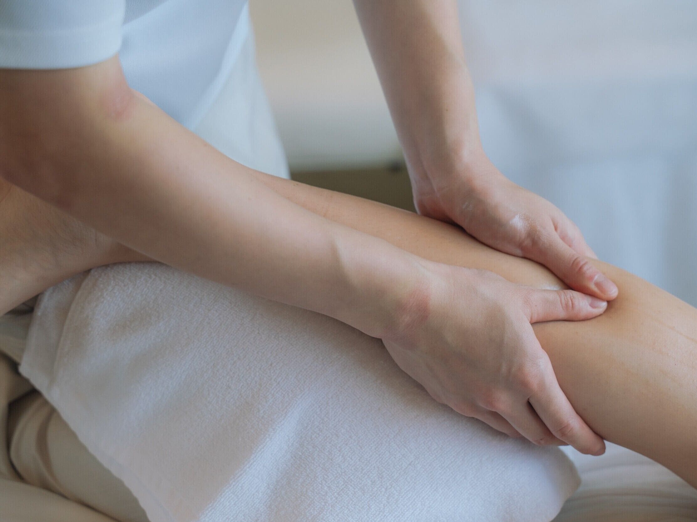 A person receiving a massage on a white massage table.