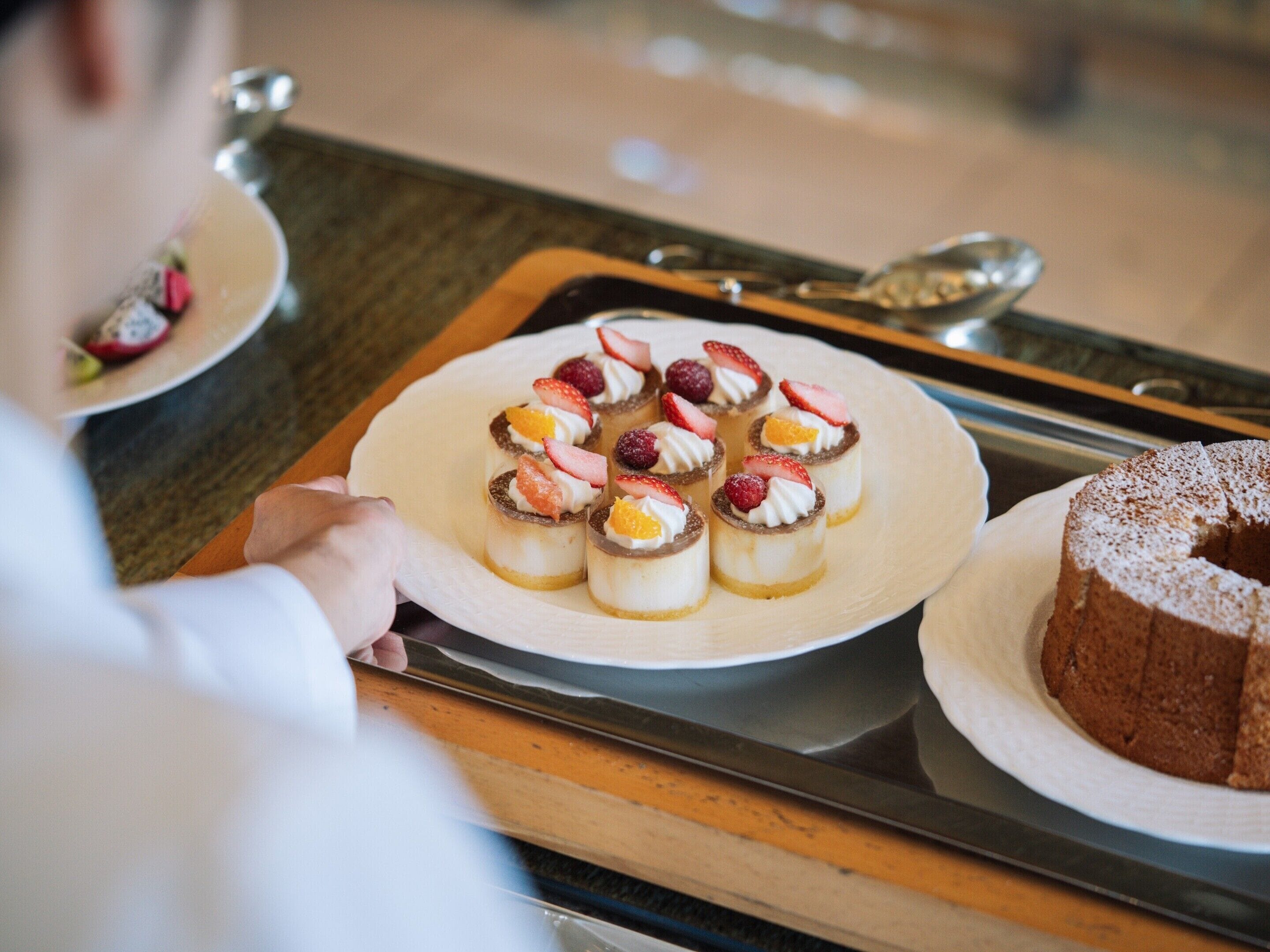 Una bandeja con una selección de mini postres y un pastel.
