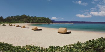 On the beach, white sand, sun loungers, beach umbrellas
