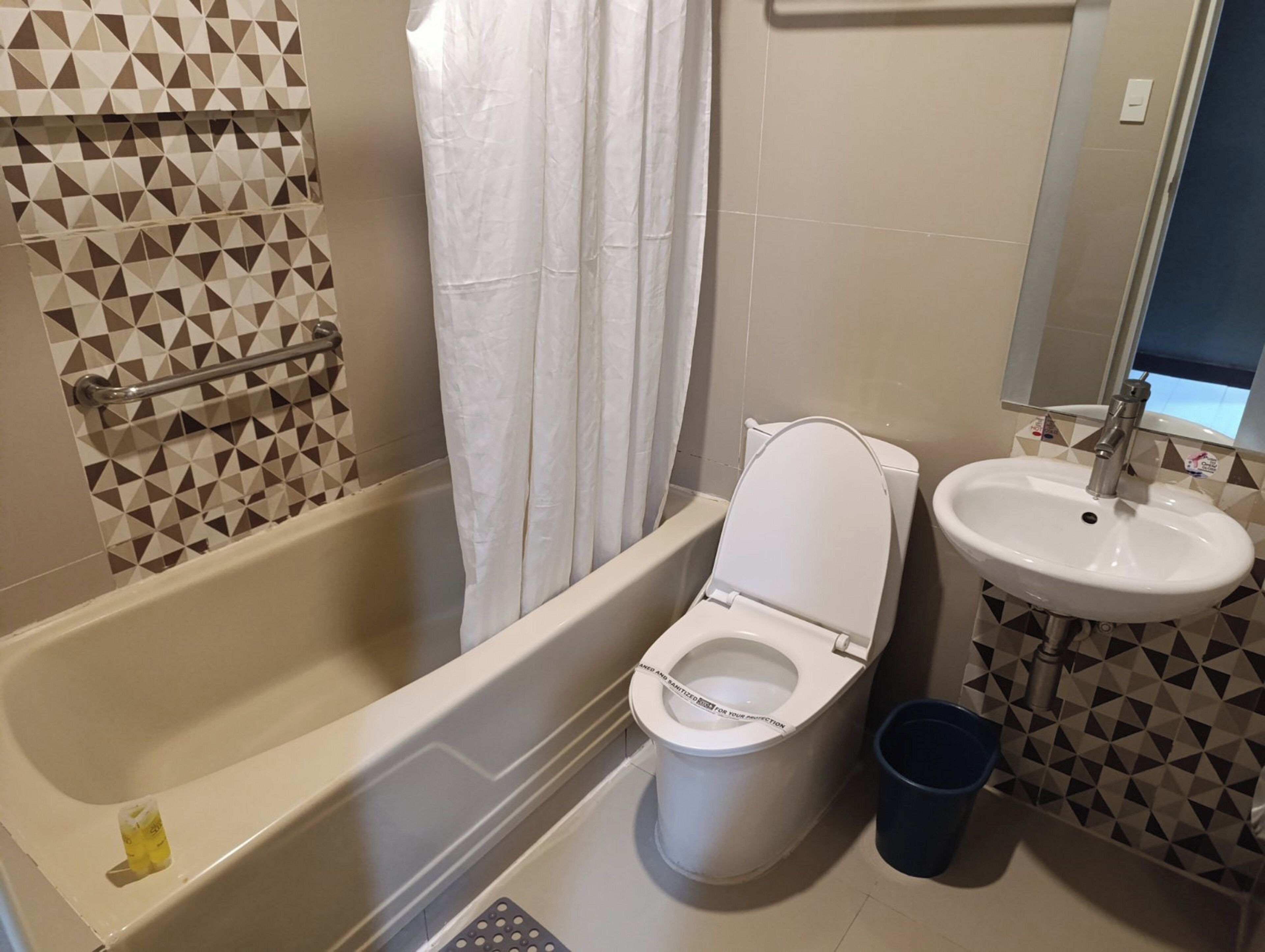 A bathroom with a bathtub, toilet, and sink.