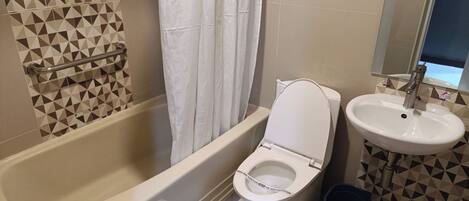 A bathroom with a bathtub, toilet, and sink.