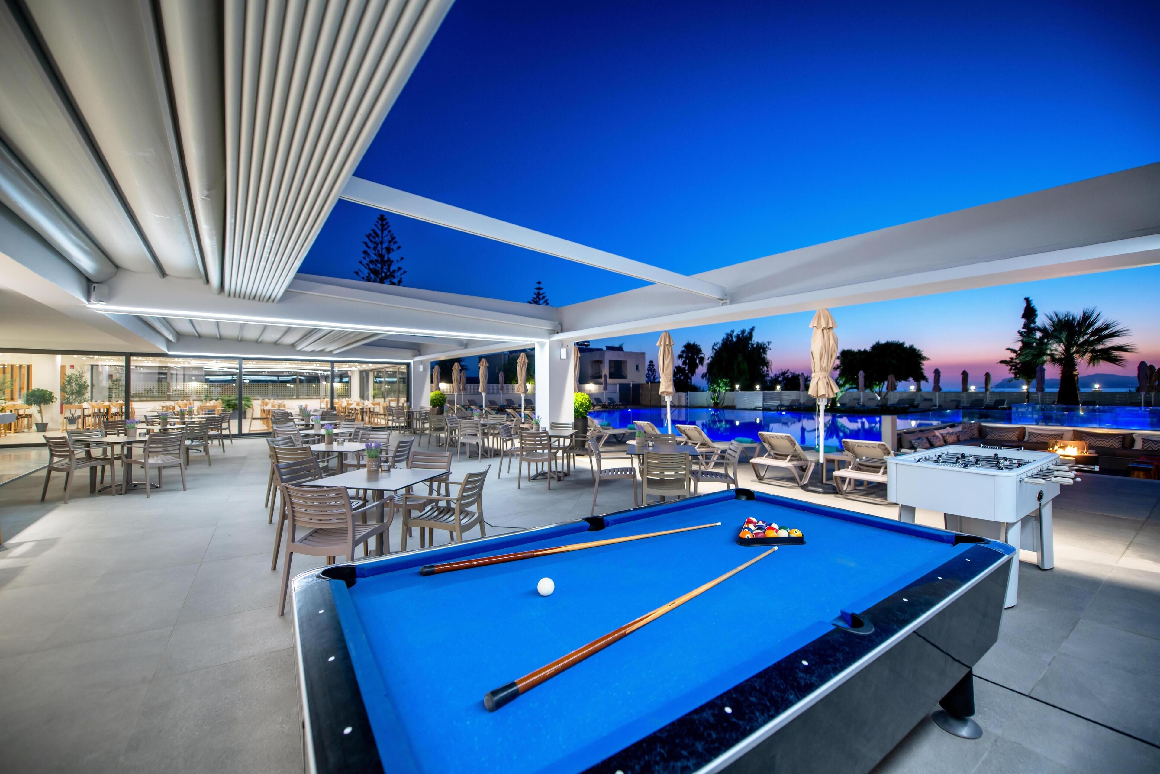 Una piscina al aire libre, sombrillas, sillones reclinables de piscina