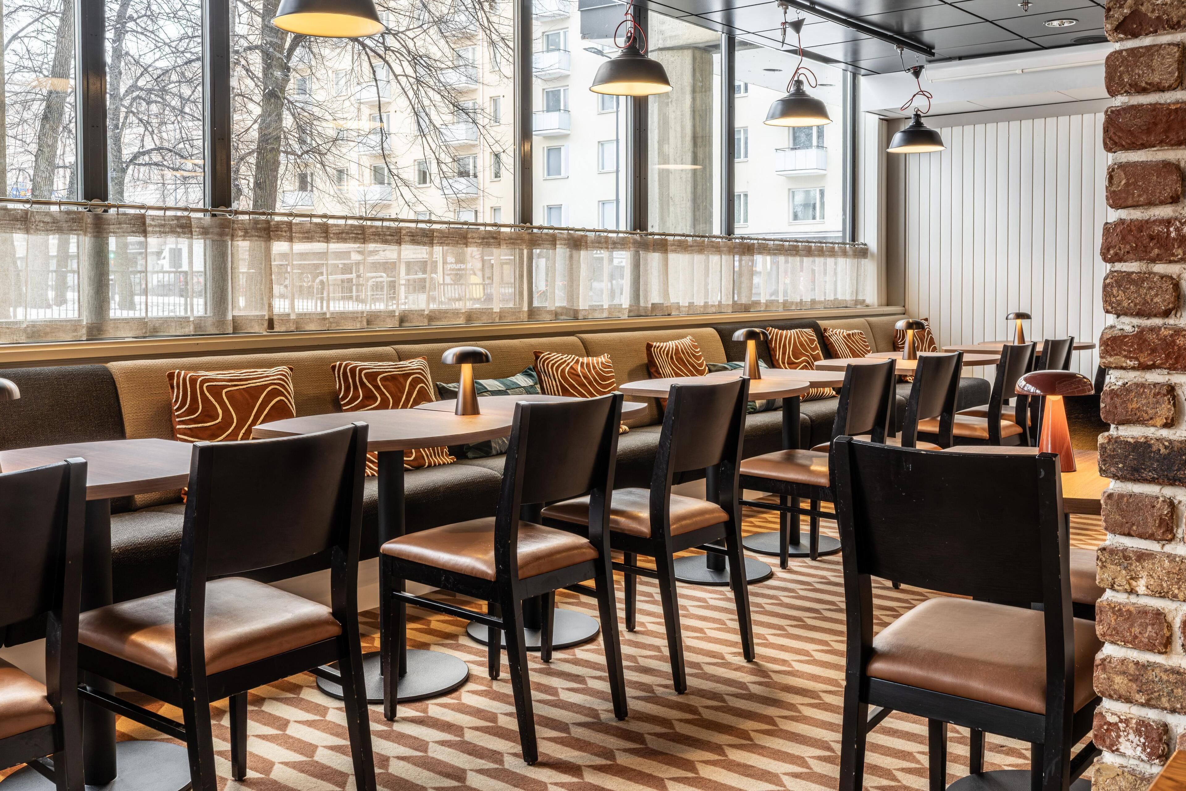 Un restaurant doté d’un long banc servant de siège, ainsi que de tables et de chaises.
