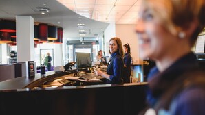 Een receptie met een gebogen plafond, een receptiebalie en een computer.