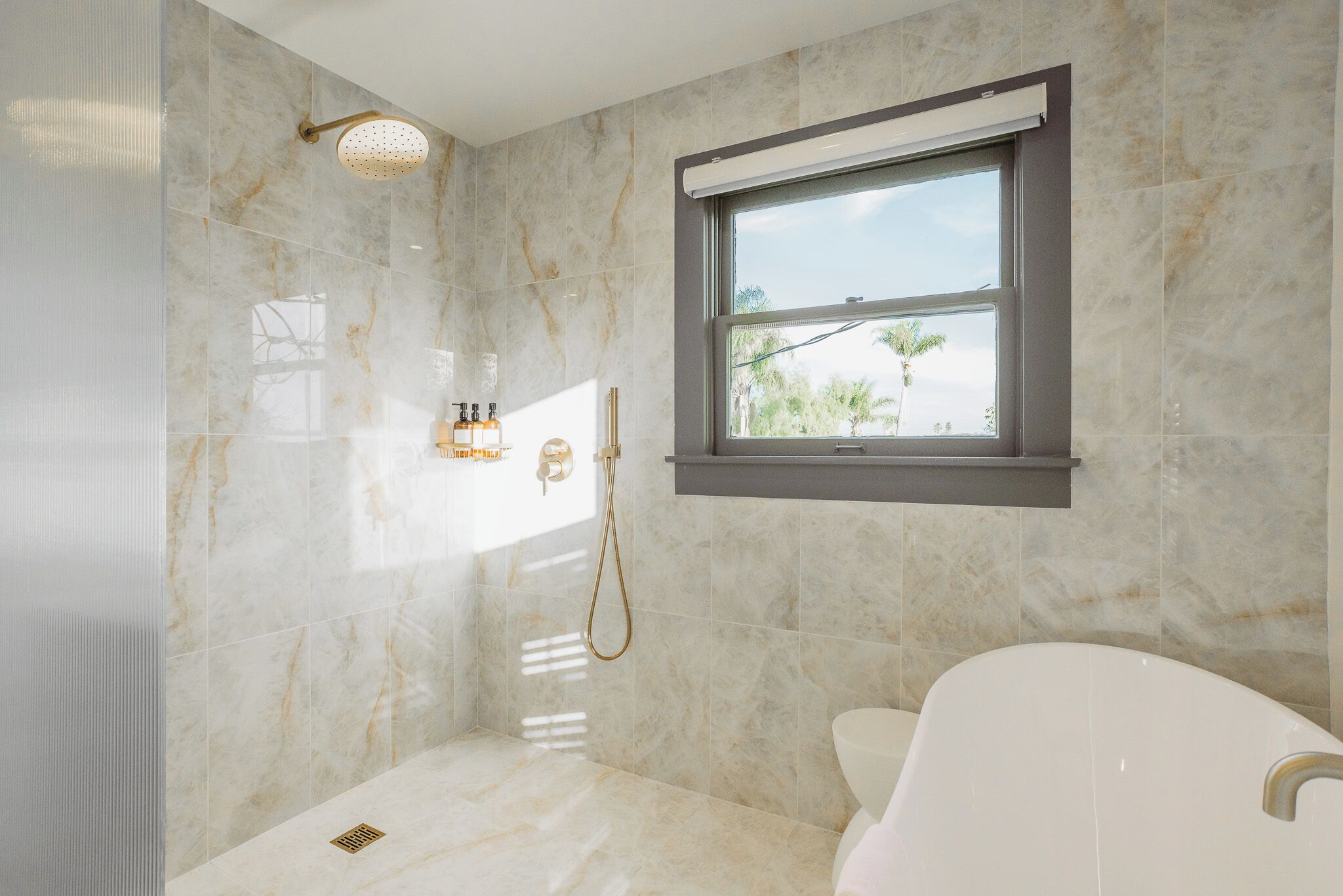 A modern bathroom with a shower, a window, and a bathtub.