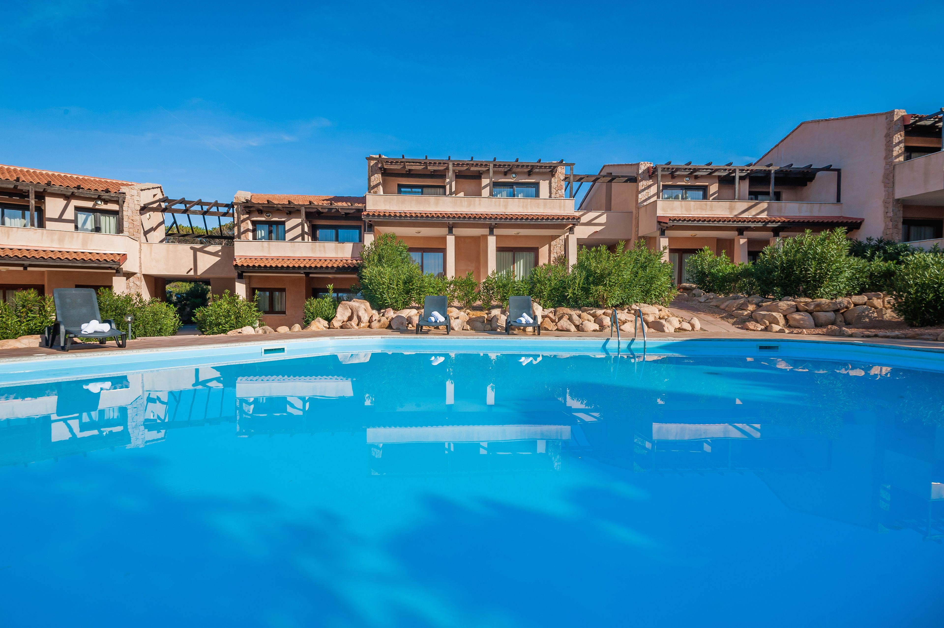 Un hôtel doté d’une piscine, de plusieurs balcons et d’une cour intérieure agrémentée de verdure.