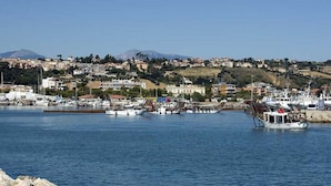 Un pueblo costero con un puerto deportivo, barcos y edificios.