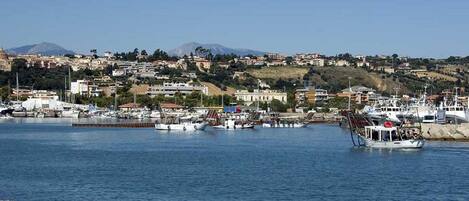 A coastal town with a marina, boats, and buildings.