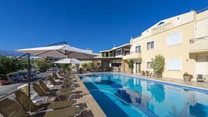 A hotel pool area with sun loungers and umbrellas, a clear blue pool, and a building labeled "VERONICA HOTEL".