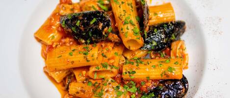 Un plato de pasta con salsa de tomate y champiñones, adornado con hierbas picadas.
