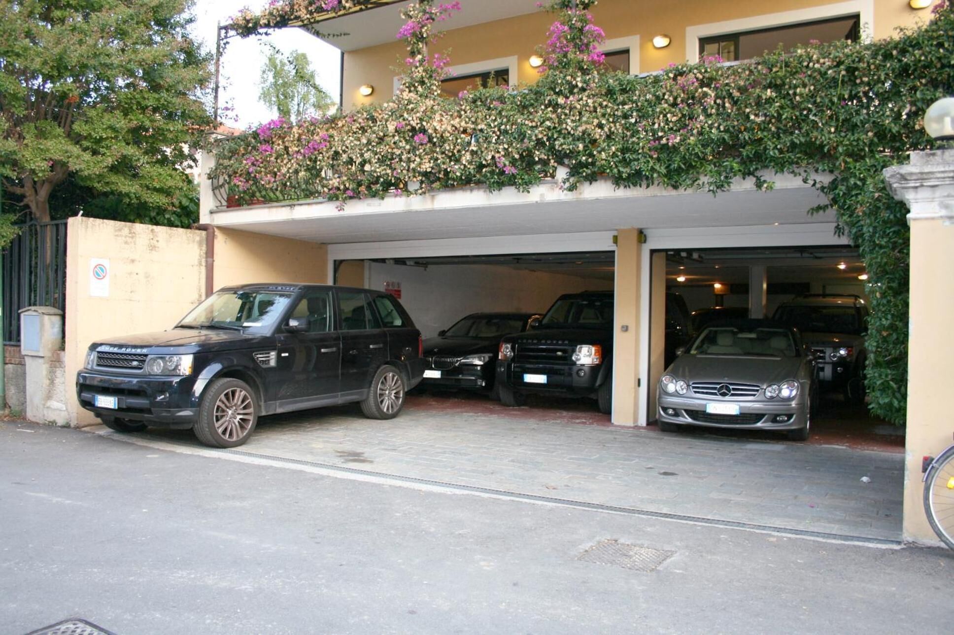 Un parking souterrain où sont garées plusieurs voitures, dont un SUV noir et une berline argentée.