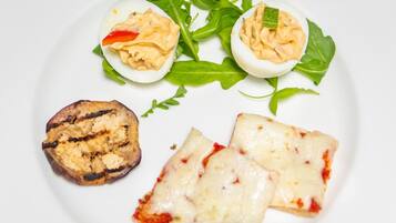 A plate with deviled eggs, grilled mushroom, and cheese slices.