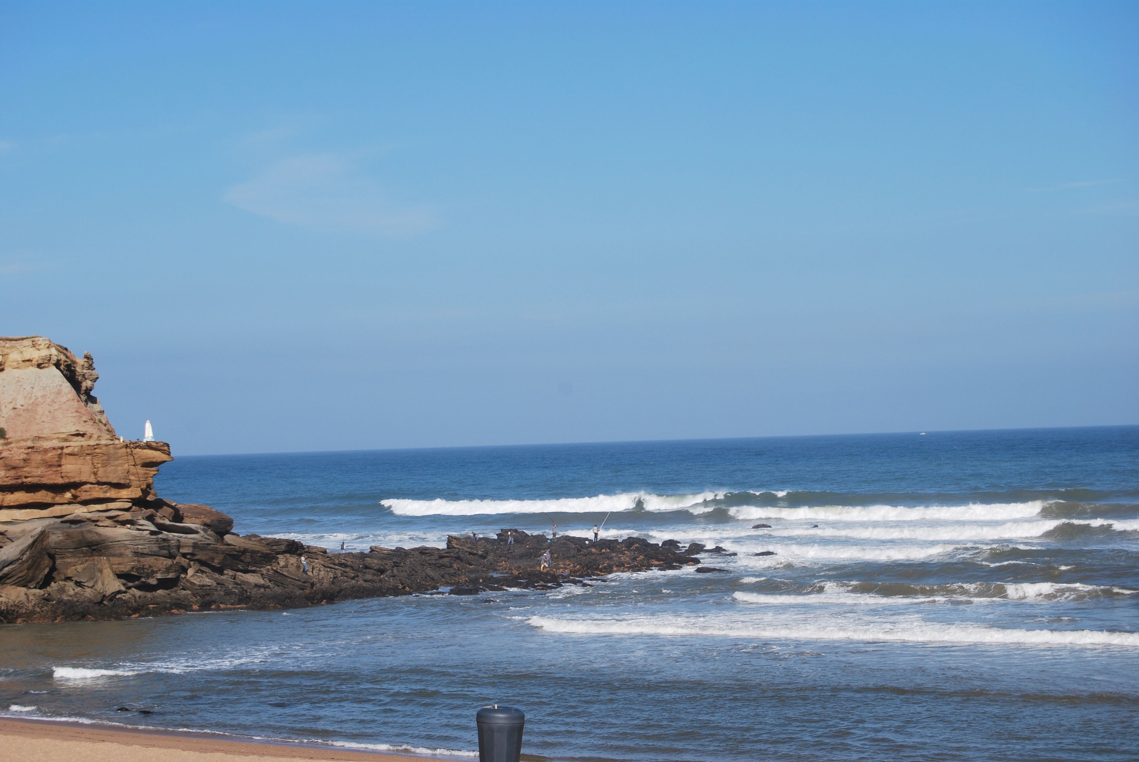 A coastal landscape with rocky cliffs and the ocean.