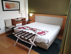 A hotel room with a bed, a desk, a chair, a lamp, and a painting on the wall. - Hotel Albergaria Borges (Chaves)